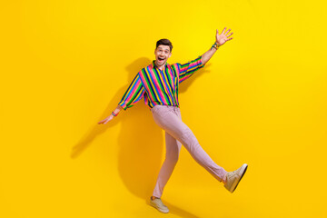 Fototapeta na wymiar Full size body photo of guy raised palms up enjoy his vintage clothing he bought in second hand isolated on yellow color background