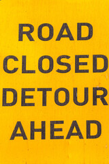 Road Sign Words Road Closed Detour Black Words Yellow Board Vertical Close Up.
