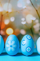 Front view of blue Easter eggs on pastel blurred background, space for copy.