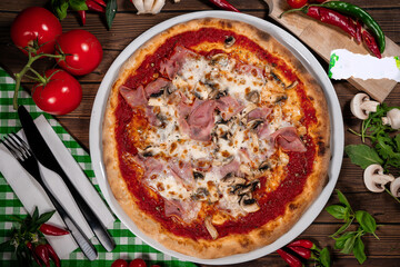 Pizza capricciosa with cooked ham, mozzarella on wooden table