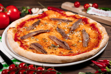 neapolitan pizza with tomatoes anchovies capers close up wooden table