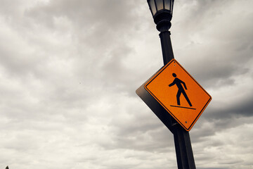 Sign of pedestrian pathway under a cloudy sky