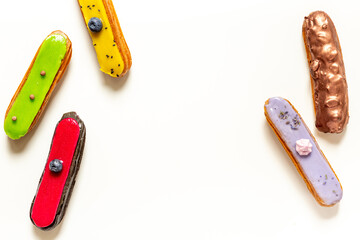 Pattern of various glased eclairs cakes. Sweet food background