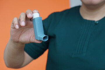 Close up patient's hand holds asthma inhaler. Concept, health care. Pharmaceutical products for...