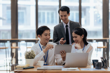 Group of young asian business people collaborate and discuss business plan during team meeting in modern office. © amnaj