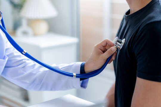 Close up of doctor is using a stethoscope listen to the heartbeat of the patient. Doctor giving a male patient a check up.