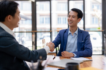 Business success. Asian Businessman shake hands to confirm agreements to do business together and invest in companies to collect capital to expand new companies.