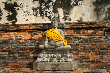 Statue de bouddha dans un temple Thaïlandais, avec des étoffes jaune orange