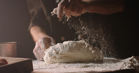 Experienced professional chef getting rid of flour on his hands, starting to make pizza or bread...