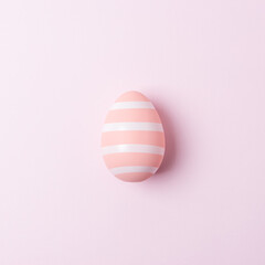 Fototapeta na wymiar Colorful Easter egg on pink background. Minimal Easter concept. Flat lay.