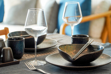 Table set for dinner in living room, closeup. Interior design,Table settings wait for guests at home or restaurant, artificial potted plant for decoration