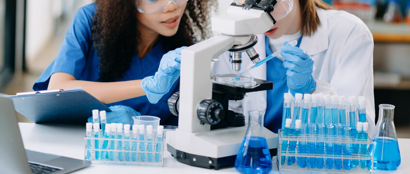 Two scientist or medical technician working, having a medical discuss meeting with an Asian senior female scientist supervisor in the laboratory with online reading, test sample - Powered by Adobe