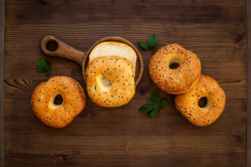 Homemade baked bread bagels on wooden board. Healthy breakfast background