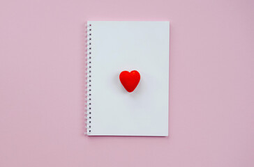St Valentine's Day concept. Top view photo of notepad on pastel pink background with copyspace
