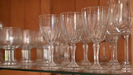 A group of clear drinking glasses on a shelf.