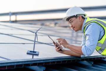 Engineer Electrician using a digital tablet to check solar panels systems on the roof, clean energy...