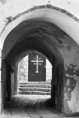 View on the door of St Michael monastery through the archway in Old Jaffa. Tel Aviv-Yafo, Israel. Black white historic photo.