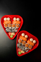 Top view of two heart-shaped sushi boxes close up