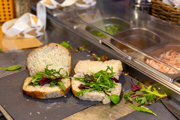 Stockholm, Sweden Sandwiches get made inside a cafe on a stainless counter.