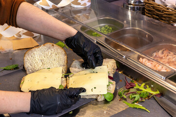 Stockholm, Sweden Sandwiches get made inside a cafe on a stainless counter.