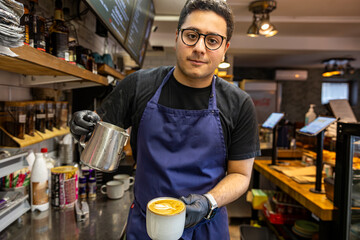 Fototapeta na wymiar Stockholm, Sweden A barista in a coffee shop mixes a cappuccino