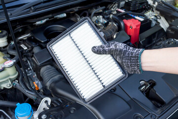 Auto mechanic hand with new car engine air filter, Car maintenance service.