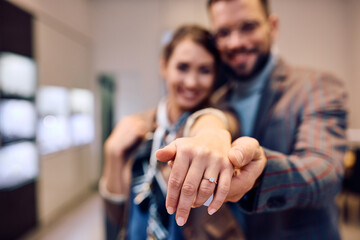 Close up of couple engagement buying ring at jewelry store - obrazy, fototapety, plakaty