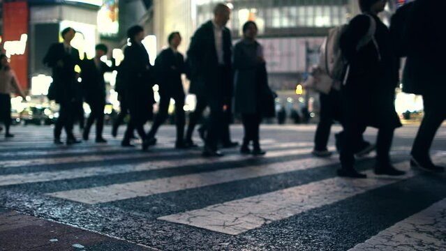 Crowd of busy unrecognisable people walking on a pedestrian crossing in Tokyo, Shibuya, Japan, pedestrian crossing at night, overcrowded urban lifestyle concept