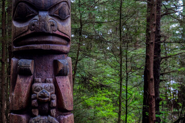 Tlingit totem poles and lush woods tree nature landscape scenery in Sitka Historical Park hiking...