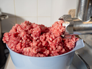 An electric meat grinder grinds meat into minced meat. Electric meat grinder close up