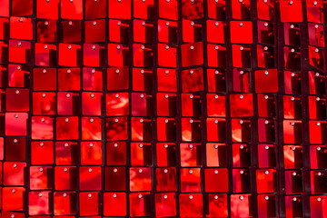 Shiny red mosaic in the shape of squares, disco texture beautiful background.