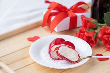 heart shaped glazed valentine cake and flowers on wooden tray
