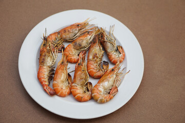 Grilled prawns, river shrimps on white plate. Concept, seafood. Delicious, favorite menu for party or outdoor barbeque or picnic. Healthy food. Ready to eat. Thai eating style.   