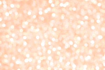 Obraz na płótnie Canvas Abstract background of blurred bokeh from Christmas sparkles out of focus in peach hue,peach shade color of the year 2024 peach fuzz, pantone 2024