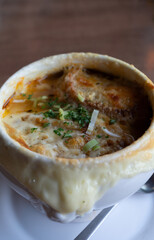 French cuisine, onion soup with melted gruyere cheese and slices of baguette served hot from oven