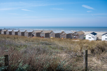 Fototapeta premium Beach holidays on sandy beach, waterfront wooden cottages in Katwijk-on-zee, North sea, Netherlands