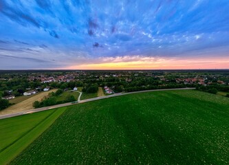 Sunset Glow Over Green Fields and Distant Town