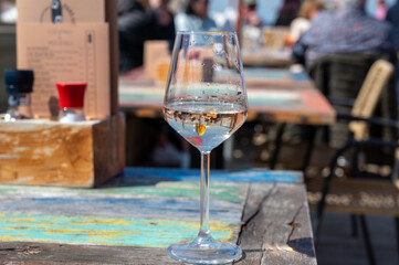 Drinking pinot grigio dry cold wine, served outdoor in beach cafe in North Holland, North sea sandy beach, the Netherlands