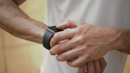 Fototapeta na wymiar Hands touching smart watch close up. Athlete check performance data on display