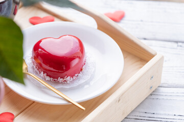 heart shaped glazed valentine cake in bed on wooden tray