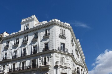 Corner of old classical building of white colour in baroque style downtown Madrid, Spain