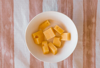 Bowl full of cheese cut into cubes. Food concept