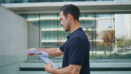 Business man putting sign at architecture place closeup. Employee holding papers