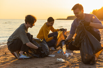 Earth day. Volunteers activists team collects garbage cleaning of beach coastal zone. Woman mans...