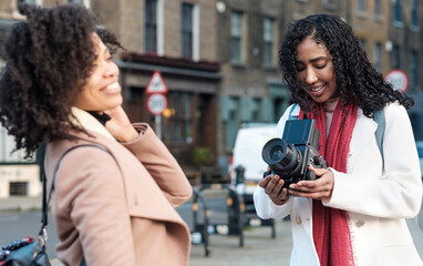 Professional female photographer doing a photoshoot with female in the street.