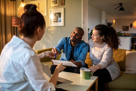 Happy couple signing contract with real estate agent