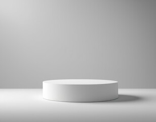 A white cylinder podium for product presentation on a white background, casting a shadow.