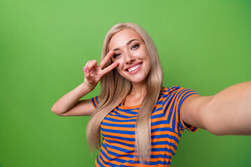Self portrait of young blonde student girl cover face v sign symbol sending congrats to subscribers...