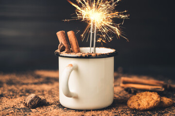 Homemade spicy hot chocolate drink with cinnamon stick, star anise, grated chocolate and sparklers...