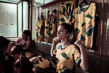 Young female football player getting ready in locker room